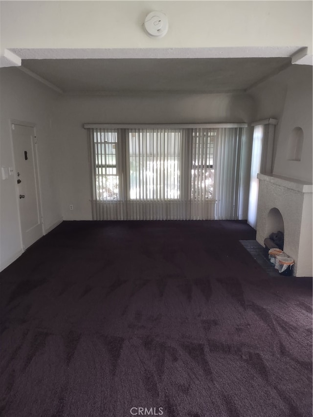 unfurnished living room with a fireplace and carpet flooring