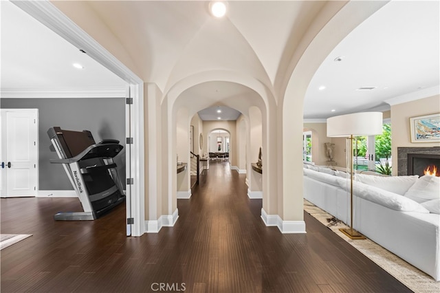 hall featuring vaulted ceiling, crown molding, and dark hardwood / wood-style flooring