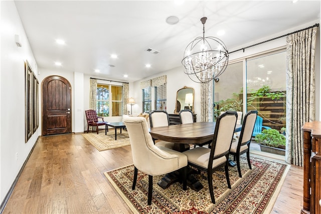 dining area featuring light hardwood / wood-style flooring and an inviting chandelier