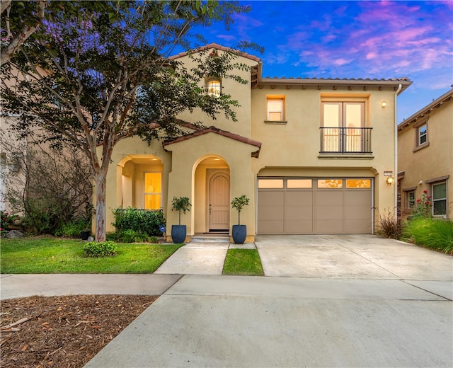 mediterranean / spanish house featuring a garage and a lawn