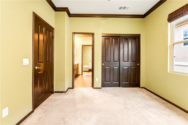 unfurnished bedroom with ornamental molding and light colored carpet