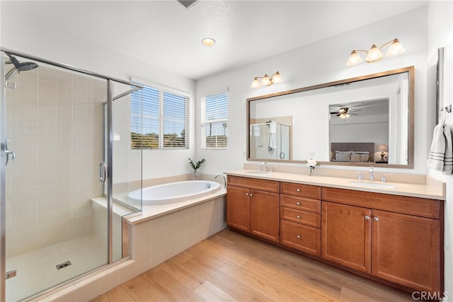 bathroom featuring hardwood / wood-style floors, vanity, separate shower and tub, and ceiling fan