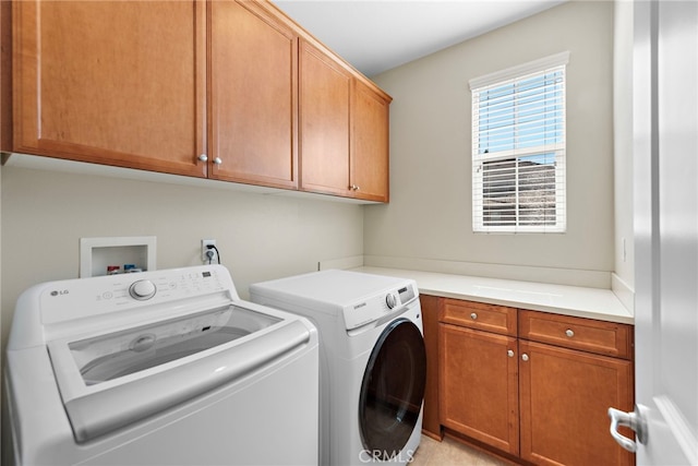 laundry area with separate washer and dryer and cabinets