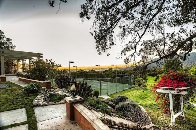 view of tennis court with a patio