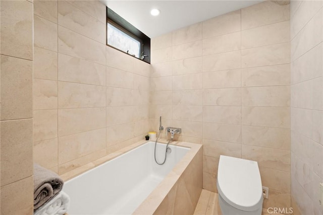 bathroom featuring a relaxing tiled tub, tile walls, and toilet