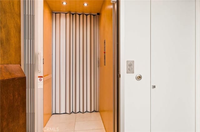 hallway with light tile patterned floors and elevator