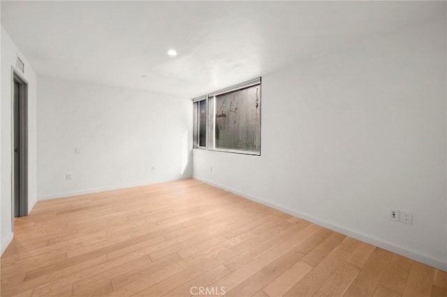 spare room with light hardwood / wood-style flooring