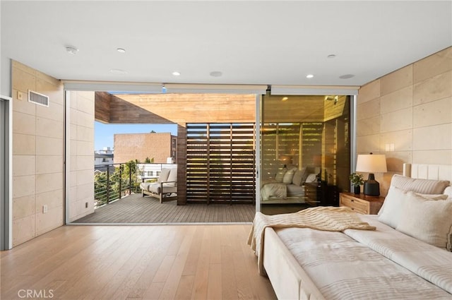 unfurnished bedroom featuring hardwood / wood-style floors and a wall of windows