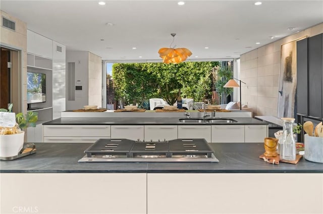 kitchen featuring white cabinetry, stainless steel gas stovetop, and sink