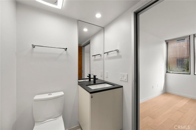 bathroom featuring hardwood / wood-style floors, vanity, and toilet