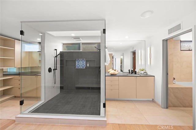 bathroom featuring hardwood / wood-style floors, vanity, and shower with separate bathtub