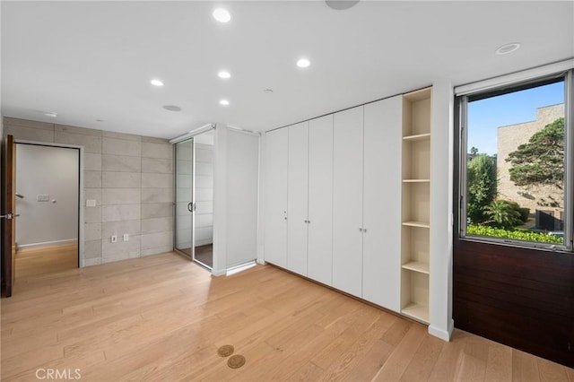 unfurnished bedroom featuring two closets and light hardwood / wood-style flooring