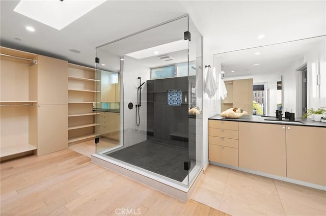 bathroom featuring wood-type flooring, vanity, and a shower with door