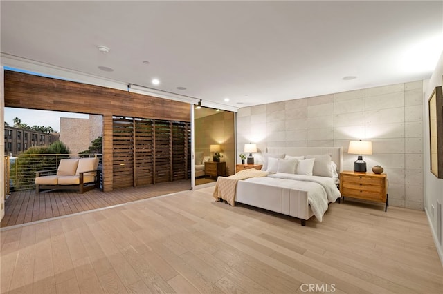 bedroom featuring tile walls and light wood-type flooring