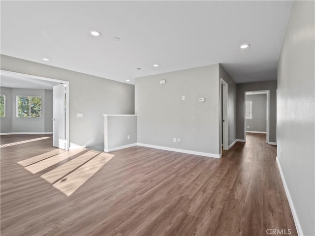 empty room featuring baseboards, wood finished floors, and recessed lighting