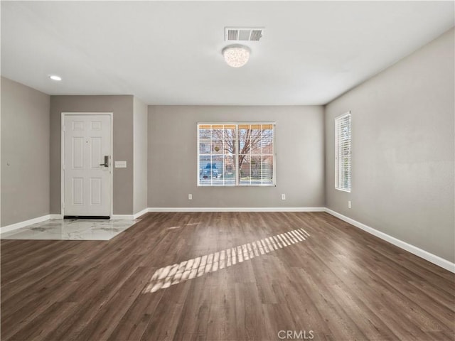 interior space featuring visible vents, baseboards, and wood finished floors