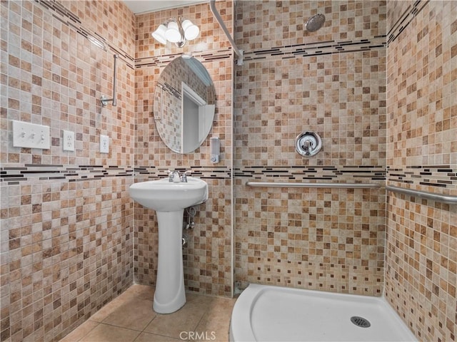 full bathroom featuring a shower stall, tile walls, and tile patterned floors