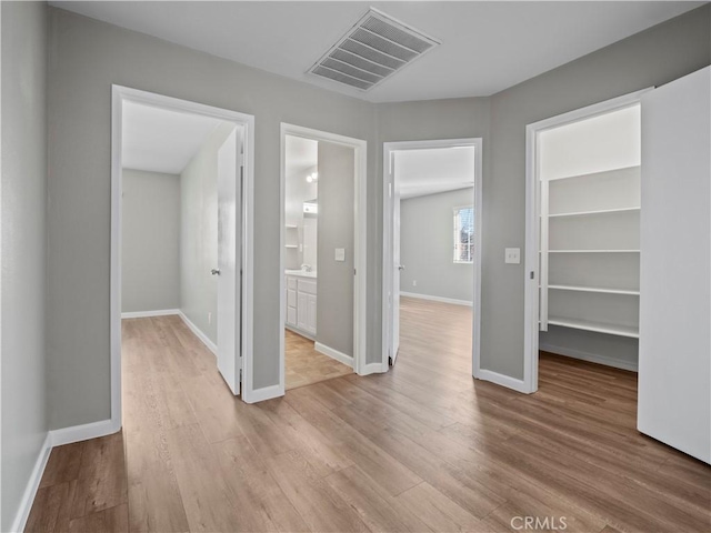 unfurnished room with baseboards, visible vents, and light wood-style floors