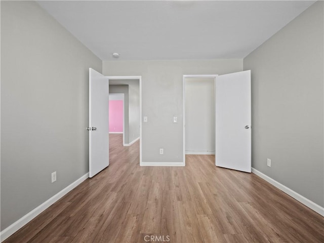 unfurnished bedroom featuring light wood finished floors and baseboards