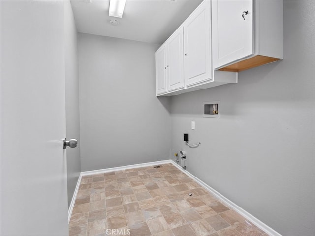 washroom featuring cabinet space, baseboards, gas dryer hookup, stone finish floor, and washer hookup