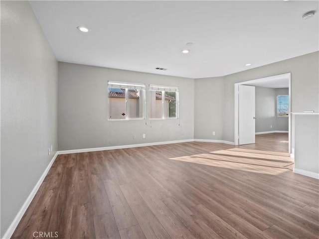 spare room with visible vents, baseboards, wood finished floors, and recessed lighting