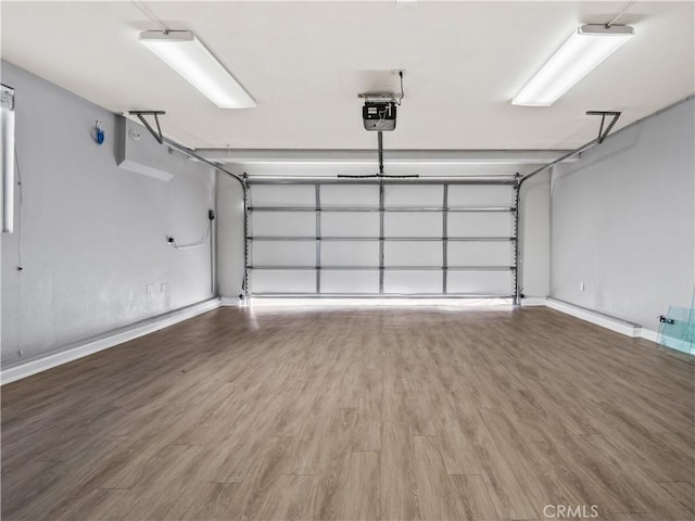 garage with a garage door opener and baseboards