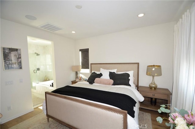 bedroom featuring light wood-type flooring and ensuite bath