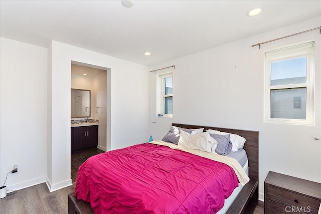 bedroom featuring dark wood-type flooring and ensuite bath