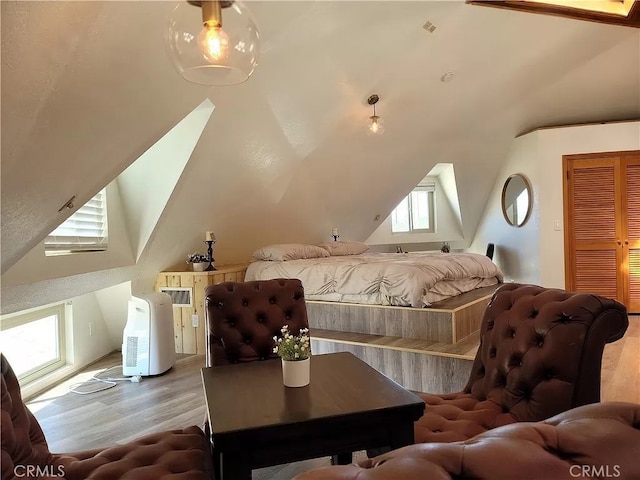 bedroom with lofted ceiling and light wood-type flooring