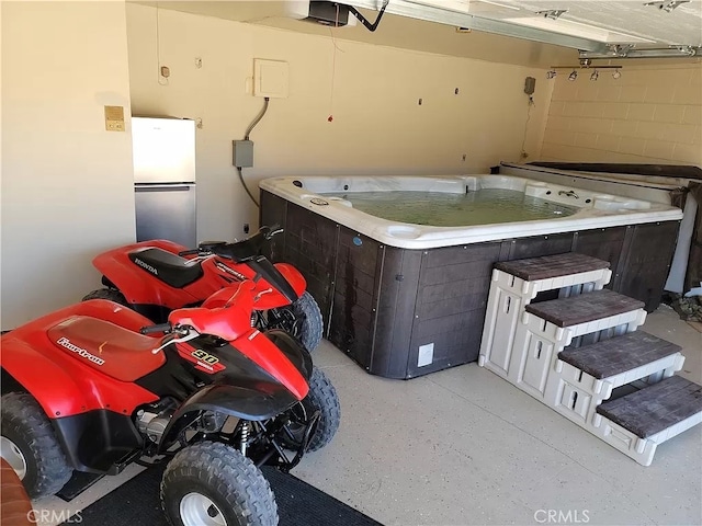 garage with washer / dryer, a garage door opener, and stainless steel fridge