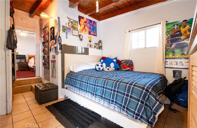 bedroom featuring beamed ceiling, wood ceiling, and tile patterned floors