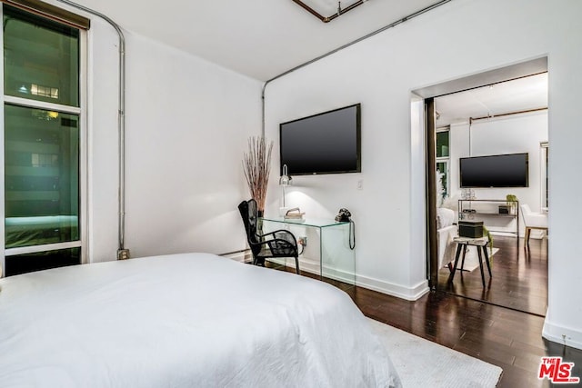 bedroom with dark hardwood / wood-style flooring