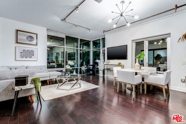 living room featuring track lighting, an inviting chandelier, and dark hardwood / wood-style flooring