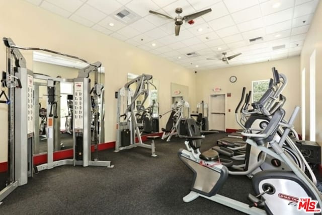 exercise room with a drop ceiling and ceiling fan