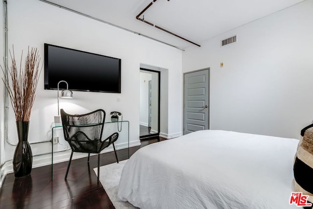 bedroom with dark hardwood / wood-style flooring