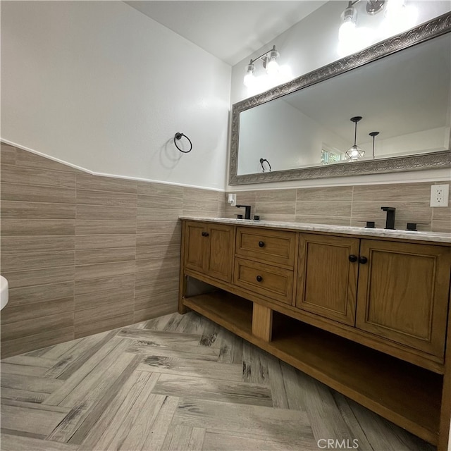 bathroom featuring vanity, parquet flooring, and tile walls