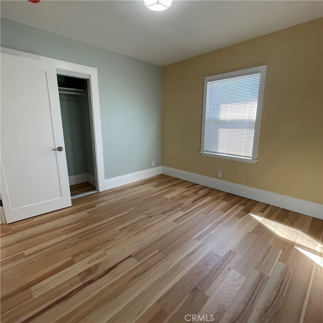 unfurnished bedroom with light hardwood / wood-style floors and a closet