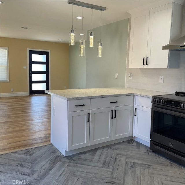 kitchen with kitchen peninsula, white cabinets, stainless steel range with electric cooktop, and wall chimney exhaust hood