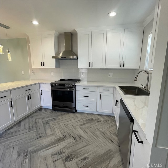 kitchen featuring stainless steel appliances, wall chimney exhaust hood, sink, and white cabinets