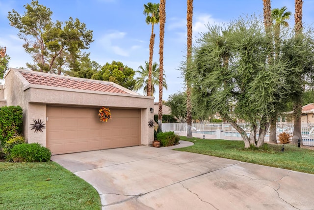 view of front of property with a community pool, a garage, and a front yard