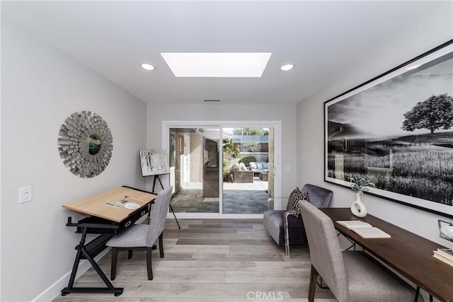 office featuring light hardwood / wood-style flooring and a skylight