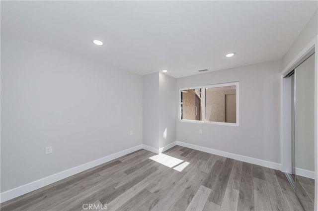 unfurnished bedroom with light hardwood / wood-style floors and a closet