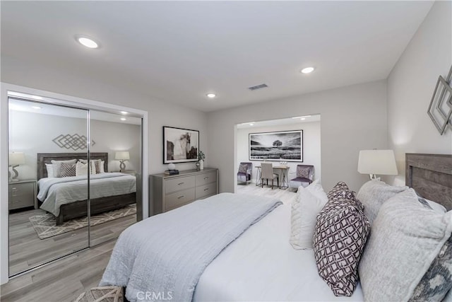 bedroom with light hardwood / wood-style floors and a closet