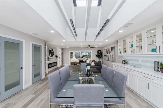 dining area with light hardwood / wood-style floors and ceiling fan