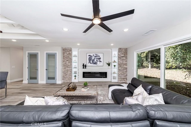 living room with ceiling fan and light hardwood / wood-style flooring