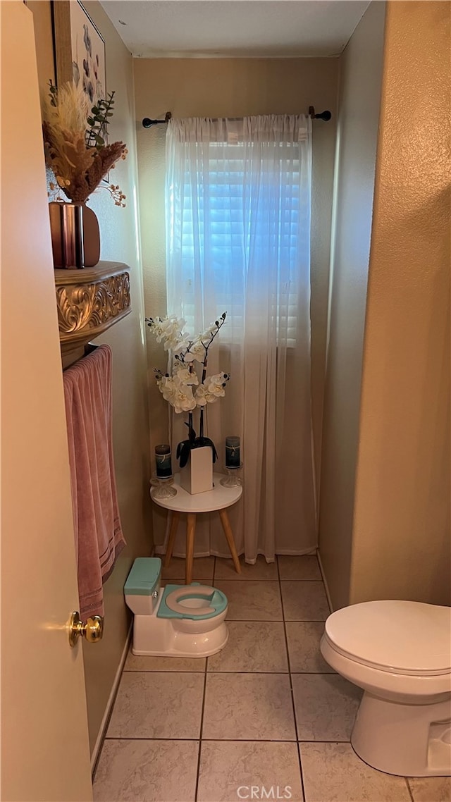 bathroom with toilet and tile patterned floors