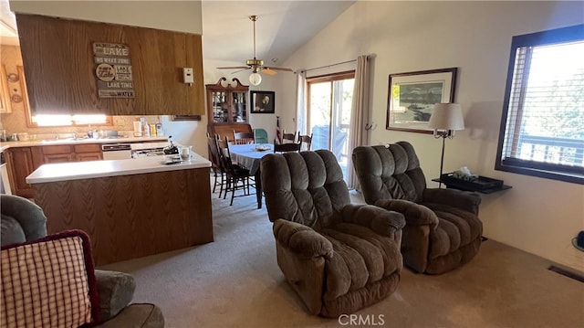 carpeted living room with lofted ceiling, ceiling fan, and sink