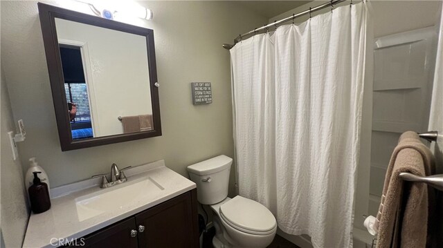 bathroom featuring vanity, toilet, and a shower with shower curtain