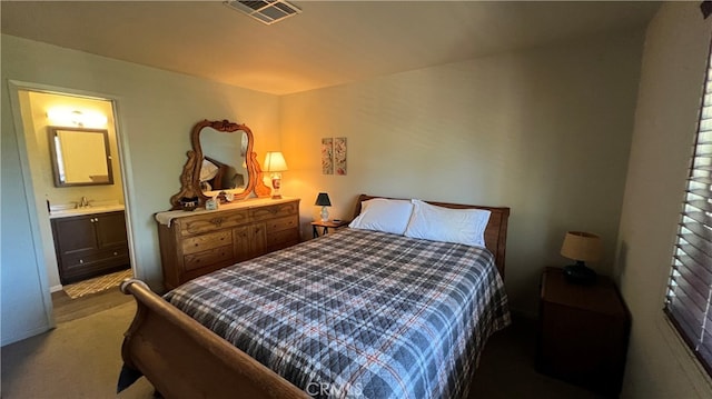 bedroom with ensuite bath, sink, and carpet