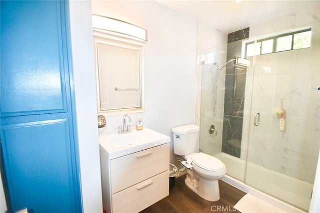 bathroom with vanity, a shower with shower door, wood-type flooring, and toilet